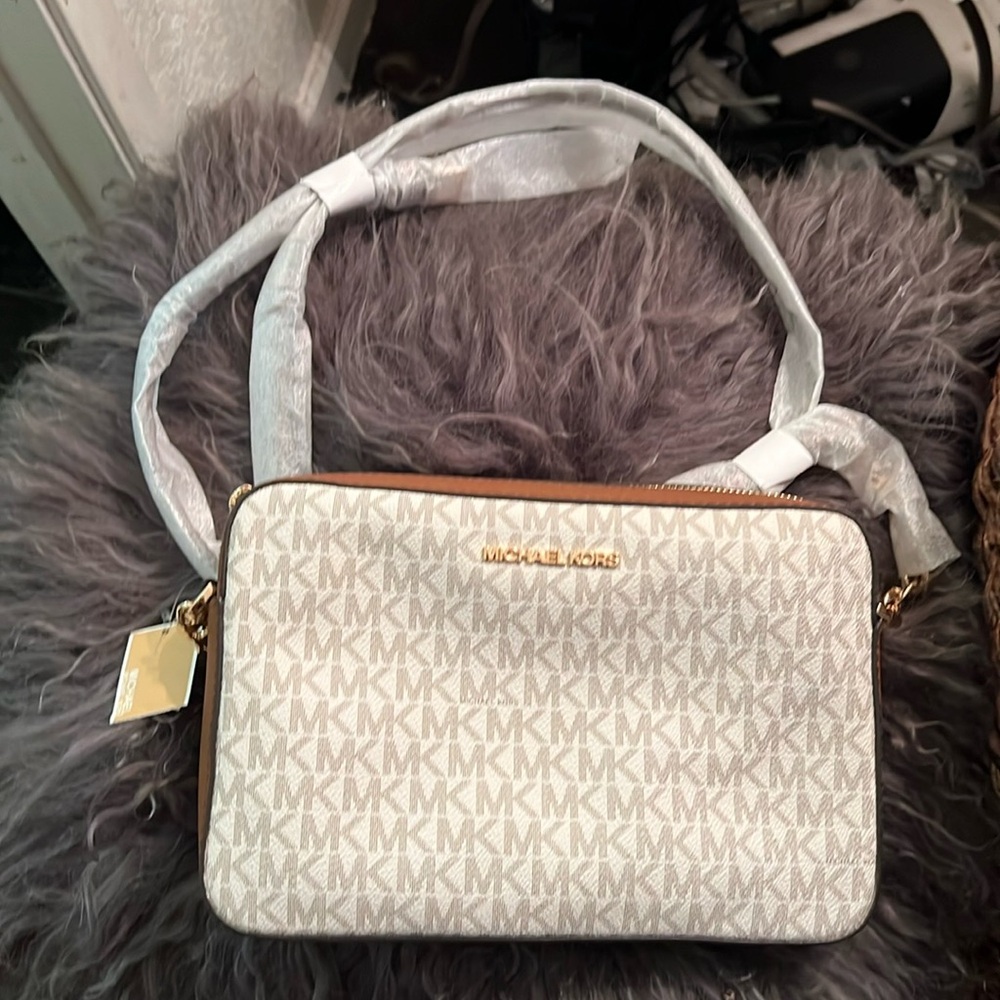 This is a Michael Kors monogram, leather, zip purse, beige